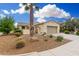 Inviting desert-landscaped home with a beige facade, featuring a palm tree and a two-car garage at 13051 W Black Hill Rd, Peoria, AZ 85383