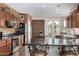 Spacious kitchen with dark wood cabinets, granite countertops, an island with a breakfast bar, and stainless steel appliances at 13051 W Black Hill Rd, Peoria, AZ 85383
