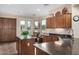 Kitchen with dark wood cabinets, granite countertops, an island with seating, and a view of the patio at 13051 W Black Hill Rd, Peoria, AZ 85383