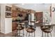 Kitchen featuring dark wood cabinets, granite countertops, a center island, and barstool seating at 13051 W Black Hill Rd, Peoria, AZ 85383