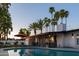 Beautiful backyard oasis with a pool, covered patio, and lush palm trees for a tranquil retreat at 1307 E Encanto St, Mesa, AZ 85203