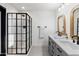 Modern bathroom featuring a double vanity, a shower with black frame, and neutral tones at 1307 E Encanto St, Mesa, AZ 85203