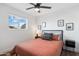 Cozy bedroom featuring a ceiling fan, natural light from window, and a stylish headboard at 1307 E Encanto St, Mesa, AZ 85203