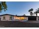 Charming single-story home featuring a well-manicured front yard, black garage door, and an inviting entrance at 1307 E Encanto St, Mesa, AZ 85203