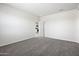 A bedroom with carpet flooring features a door leading to the kitchen space at 1343 W Hess Ave, Coolidge, AZ 85128