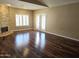 Inviting living room featuring hardwood floors, a stone fireplace, and glass doors to the outside at 1348 E Los Arboles Dr, Tempe, AZ 85284