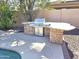 Outdoor kitchen boasts a built-in grill and counter space, ideal for outdoor entertaining near the pool at 1348 E Los Arboles Dr, Tempe, AZ 85284