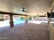 Covered patio with stone flooring overlooking a sparkling pool and outdoor kitchen at 1348 E Los Arboles Dr, Tempe, AZ 85284