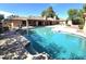 Inviting pool featuring a basketball hoop and lush landscaping, with a covered patio on beautiful grounds at 1348 E Los Arboles Dr, Tempe, AZ 85284