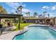 Backyard featuring a pool, covered seating areas, grass and palm trees at 13631 N Canterbury Dr, Phoenix, AZ 85023
