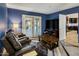 Living room with blue walls, French doors, modern furniture, and an adjacent kitchen at 13631 N Canterbury Dr, Phoenix, AZ 85023
