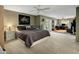 Spacious main bedroom with a large bed, ceiling fan, and views to an office space and sliding door to the backyard at 13631 N Canterbury Dr, Phoenix, AZ 85023