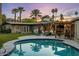A beautiful outdoor pool area with palm trees and a covered patio, perfect for relaxation and entertainment at 13631 N Canterbury Dr, Phoenix, AZ 85023