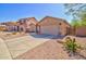 Spacious home featuring a wide driveway, two-car garage, and desert landscaping at 1385 E Martha Dr, Casa Grande, AZ 85122