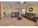 Inviting living room featuring neutral carpeting, a ceiling fan, and comfortable leather sofas at 1385 E Martha Dr, Casa Grande, AZ 85122