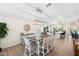 Bright dining room with a wooden table, white chairs, and modern lighting, open to the kitchen at 14241 N 56Th Pl, Scottsdale, AZ 85254