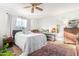 Bright bedroom featuring a cozy bed, ceiling fan, and a large window with natural light at 14261 N Oakwood Ln, Fountain Hills, AZ 85268