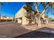 Exterior of condo with covered parking, wrought iron staircase, mature trees, and desert landscaping on a bright sunny day at 14261 N Oakwood Ln, Fountain Hills, AZ 85268
