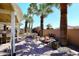 Expansive backyard with a waterfall feature, fire pit, patio, and mature palm trees, perfect for entertaining at 15061 W Pinchot Ave, Goodyear, AZ 85395