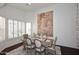 Dining room showcases a large wall art piece, plantation shutters, and wood dining table at 15061 W Pinchot Ave, Goodyear, AZ 85395