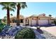 Inviting desert home featuring a gated entrance, mature palm trees, and a three car garage at 15061 W Pinchot Ave, Goodyear, AZ 85395