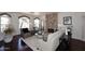 Bright living room with hardwood floors, a stone fireplace and two arched windows at 15061 W Pinchot Ave, Goodyear, AZ 85395