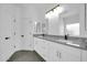 Bathroom features double sinks with granite countertops, white cabinetry, and modern fixtures at 15856 W Calavar Rd, Surprise, AZ 85379