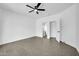 An airy room with a ceiling fan features neutral colors and tiled flooring at 15856 W Calavar Rd, Surprise, AZ 85379