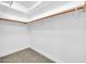 An empty walk-in closet with white walls and installed hanging rods ready for organization at 15856 W Calavar Rd, Surprise, AZ 85379