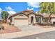 Charming single-story home with a well-manicured front yard and two-car garage at 15856 W Calavar Rd, Surprise, AZ 85379