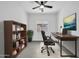 Inviting home office with ceiling fan, modern desk and chair, and a stylish bookcase for organized storage at 15856 W Calavar Rd, Surprise, AZ 85379