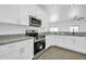Close-up of the kitchen with stainless steel appliances, granite countertops, and white cabinetry at 15856 W Calavar Rd, Surprise, AZ 85379