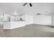 Open-concept living area with views into the kitchen, featuring neutral colors and gray tile flooring at 15856 W Calavar Rd, Surprise, AZ 85379
