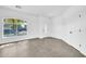 Bright living room featuring gray tile floor, large windows, and modern white interior doors at 15856 W Calavar Rd, Surprise, AZ 85379