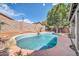 A charming pool with a small waterfall feature is surrounded by desert landscaping at 15856 W Calavar Rd, Surprise, AZ 85379