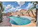 Lush backyard oasis featuring a private pool with a stone waterfall, tropical landscaping, and clear blue water at 15856 W Calavar Rd, Surprise, AZ 85379