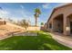 A spacious backyard with artificial grass, desert landscaping, and a raised block wall at 17128 E Kensington Pl, Fountain Hills, AZ 85268