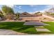 Large backyard featuring artificial grass, desert plants, a small retaining wall, and privacy wall at 17128 E Kensington Pl, Fountain Hills, AZ 85268