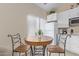 Eat-in kitchen features a cozy table and chairs, complemented by bright, white cabinetry at 17128 E Kensington Pl, Fountain Hills, AZ 85268