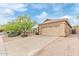 Exterior view of a single-story home showcasing a two-car garage, neutral paint, and desert landscaping at 17128 E Kensington Pl, Fountain Hills, AZ 85268