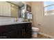 Stylish bathroom featuring dark cabinetry, a white countertop, and modern fixtures at 17656 W Bajada Rd, Surprise, AZ 85387