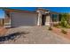 Home exterior featuring a stone veneer accent, paver driveway, and two car garage at 17656 W Bajada Rd, Surprise, AZ 85387