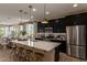 Spacious kitchen featuring black cabinets, stainless steel appliances, and bar stool seating at 17656 W Bajada Rd, Surprise, AZ 85387