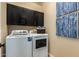 Modern laundry room featuring a front-load washer and dryer set, and overhead cabinets for storage at 17656 W Bajada Rd, Surprise, AZ 85387