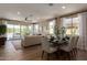 Bright living room featuring an open-concept layout with wood-style flooring and a dining area with outdoor views at 17656 W Bajada Rd, Surprise, AZ 85387