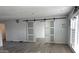 Open-concept living area with wood-look tile floors, natural light, and modern sliding barn doors at 18828 N 17Th Dr, Phoenix, AZ 85027