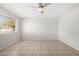 Bright bedroom with a neutral color palette, tiled floor, ceiling fan, and a large window at 1985 S Plaza Dr, Apache Junction, AZ 85120