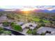 Aerial view of a beautiful desert home at sunset, surrounded by lush landscaping and mountain views at 21397 N 78Th St, Scottsdale, AZ 85255