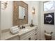 Elegant bathroom featuring a decorative mirror, sconces, and vanity with black accents at 21397 N 78Th St, Scottsdale, AZ 85255