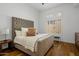 Comfortable bedroom with a tufted headboard and hardwood floors at 21397 N 78Th St, Scottsdale, AZ 85255